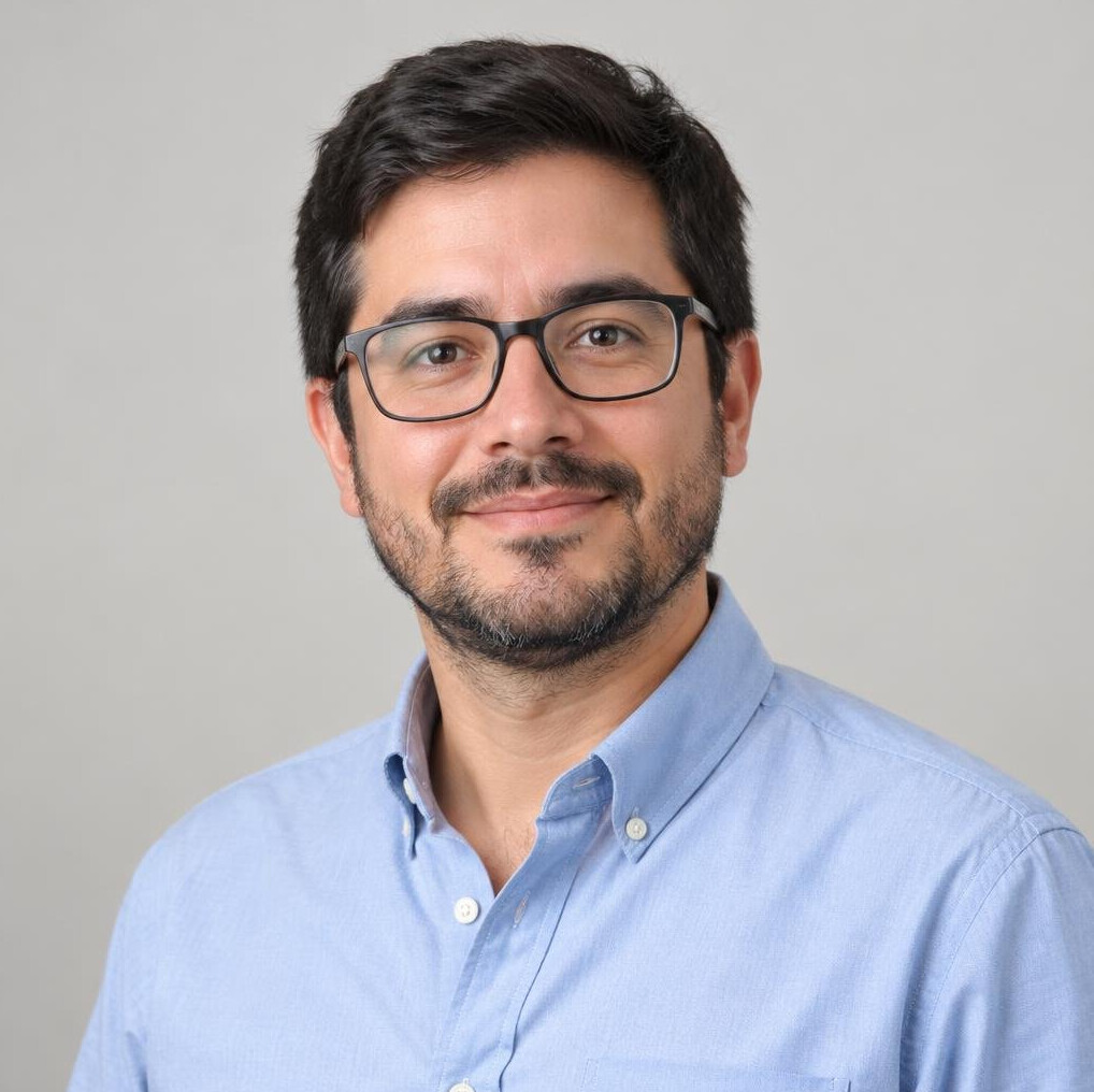 Studio portrait of a Latino man in his thirties with a short beard and glasses