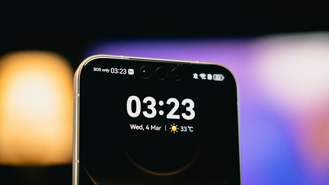 Smartphone with notification icons on a desk next to a coffee cup