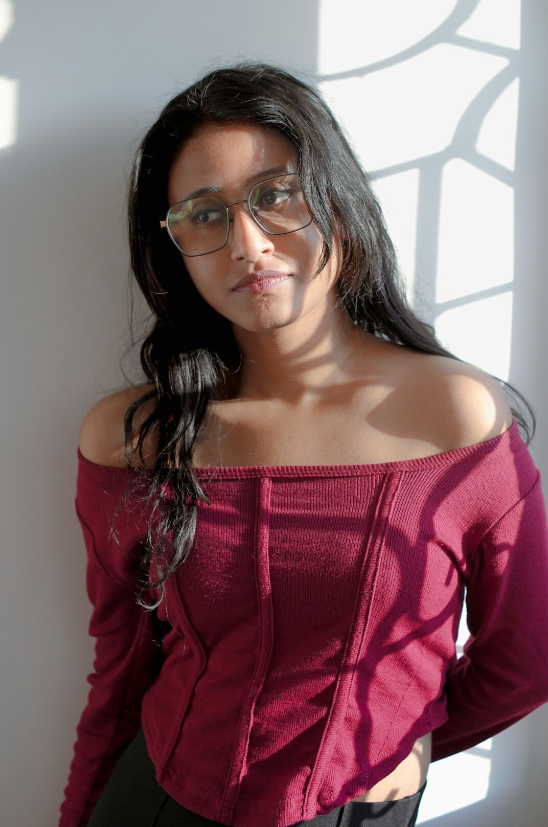 Studio portrait of a Latina woman in her forties with shoulder-length hair and glasses